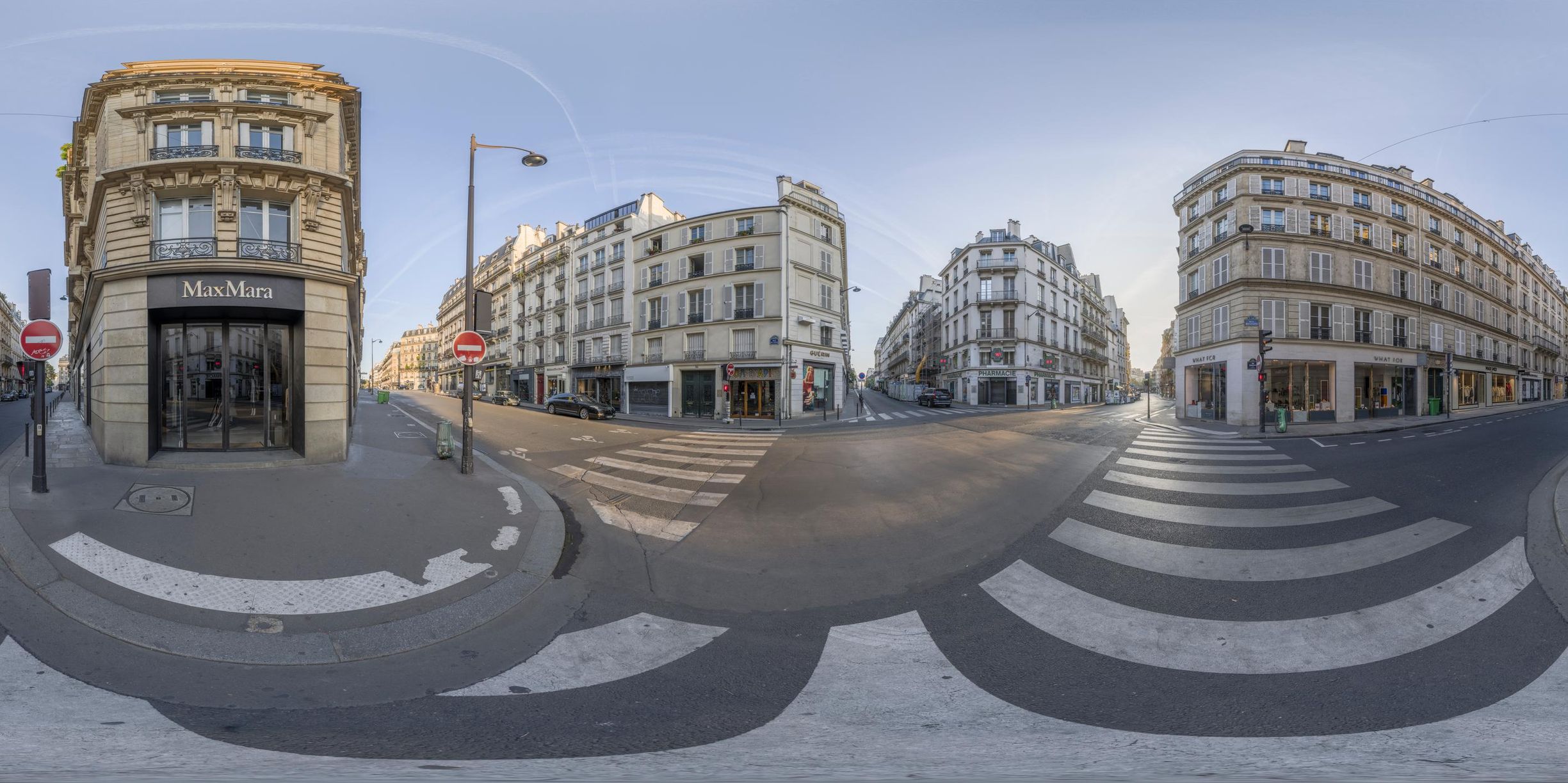 this is a panoramic image of paris buildings and people at the intersection of a busy street