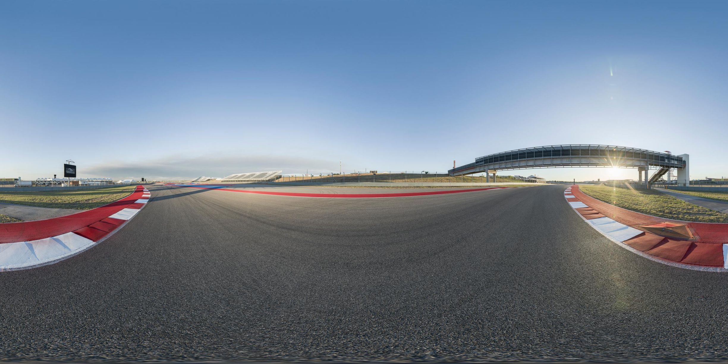the view from the top of a racing track with a sun shining behind it in a panoramic