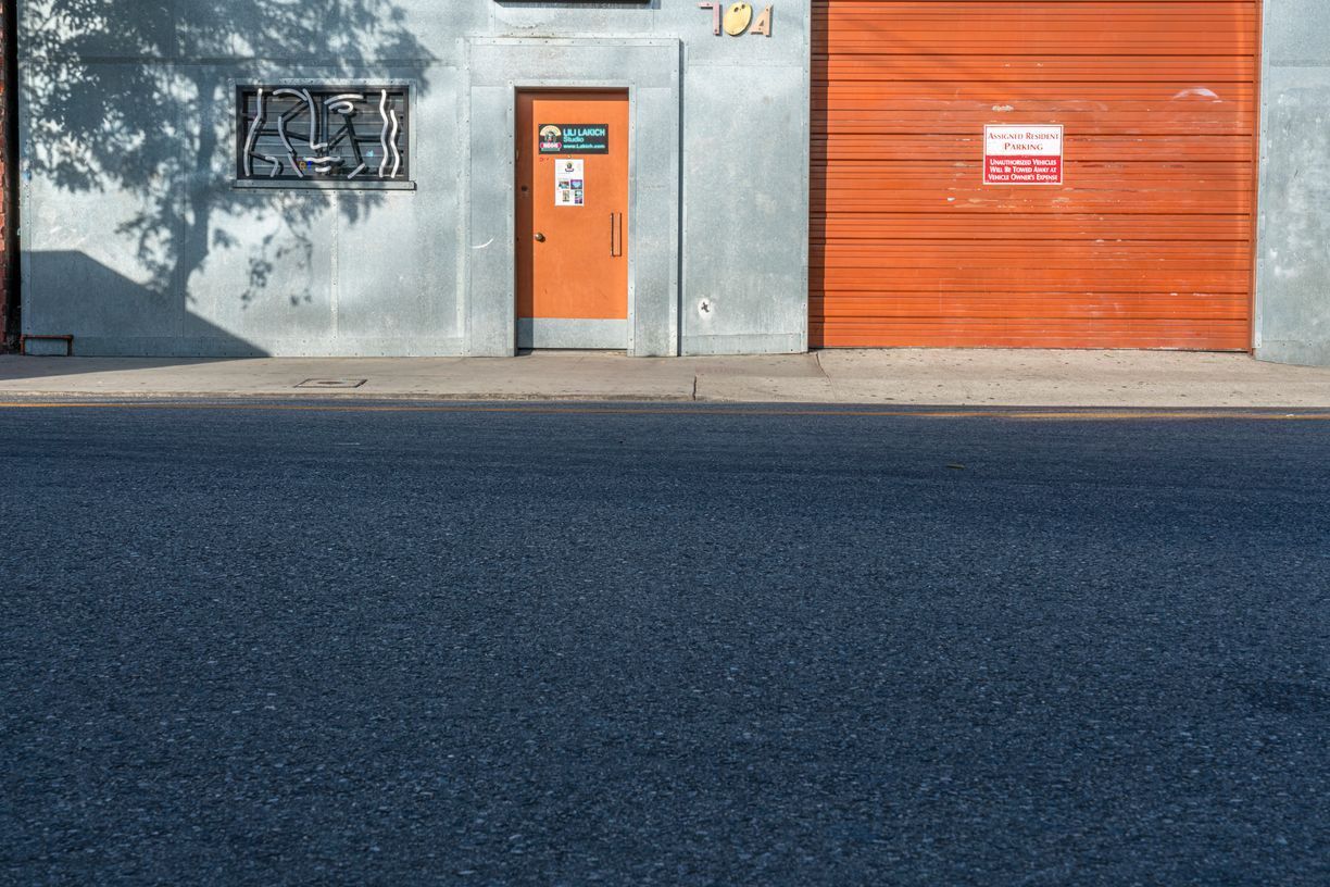 an image of a door, on the side of the building near the fire hydrant and in the foreground it is a mural of a woman with the sunliting