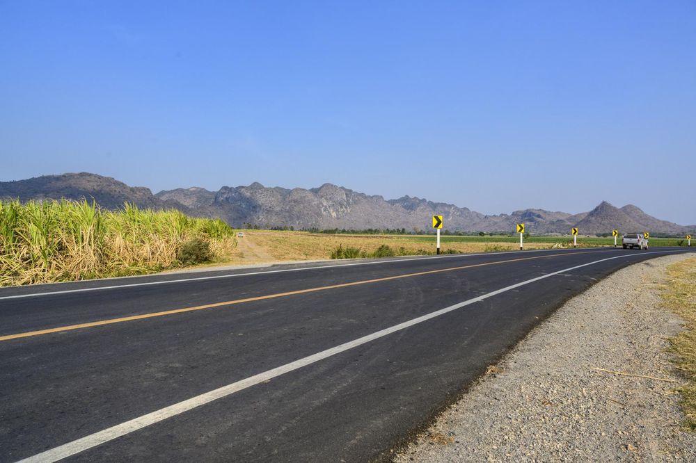 Three Road Signs on a Highway with Mountain Landscape