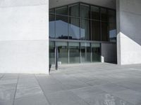 a person walking down the side of a building carrying a suitcase next to it on a stone floor