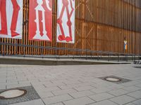 a group of people riding skateboards near wooden panels and stairss with artwork on them