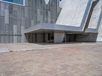 a white building with several steps and large glass panels in the facade is a mosaic that depicts a man