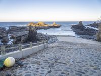 an abandoned bridge over looking the water at a rocky beach side area with rocks and water