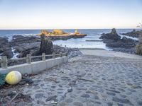 an abandoned bridge over looking the water at a rocky beach side area with rocks and water