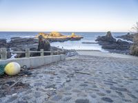 an abandoned bridge over looking the water at a rocky beach side area with rocks and water