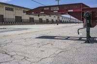 a stop sign sits in a empty area in front of an abandoned building and an old parking lot