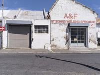 an old building in an abandoned city setting next to a street with signs on it