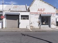 an old building in an abandoned city setting next to a street with signs on it