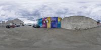 this is the bottom of a skate board ramp in an abandoned city setting with colorful doors and graffiti