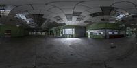 a panoramic view of an empty industrial warehouse with green paint on the floor