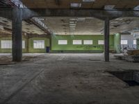 a very big building with some green walls and windows, with lots of broken wood