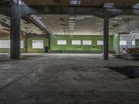 a very big building with some green walls and windows, with lots of broken wood