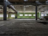 a very big building with some green walls and windows, with lots of broken wood