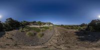 a 360 - ray photograph of an abandoned farm near a beach shore near the ocean