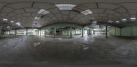 a 360 - view camera fish - eye image shows an abandoned warehouse with no doors