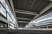 an abandoned parking garage in front of skyscrapers, with tracks on the concrete floor