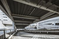 an abandoned parking garage in front of skyscrapers, with tracks on the concrete floor