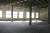the sun is shining through large windows into a warehouse area in an old brick building