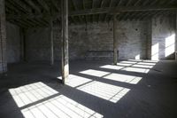 empty brick warehouse space with open floor plan and windows, in the early evening sun