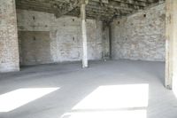 empty brick warehouse space with open floor plan and windows, in the early evening sun