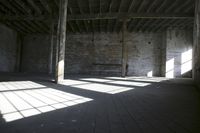 empty brick warehouse space with open floor plan and windows, in the early evening sun