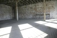 empty brick warehouse space with open floor plan and windows, in the early evening sun