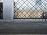 there is a woman standing outside a glass building that looks like an abstract structure with a geometric pattern