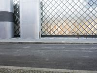 there is a woman standing outside a glass building that looks like an abstract structure with a geometric pattern