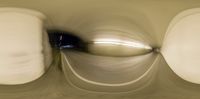 abstract photograph of toilet lid, white tank, and seat with blurry surface below