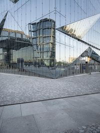 an abstract building reflecting its own reflection on the floor of a stone square and wall