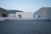 a view of two large white buildings outside one another and an open space on top of them