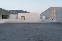 a view of two large white buildings outside one another and an open space on top of them