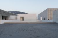 a view of two large white buildings outside one another and an open space on top of them