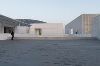 a view of two large white buildings outside one another and an open space on top of them