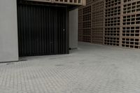 the small building has shuttered doors open on one side and some black bars along one side