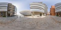 this is a fisheye lens photo of a building and some buildings on it's side