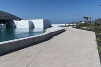 a large body of water that is next to a concrete building in the distance is a river and an arch