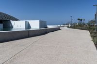 a large body of water that is next to a concrete building in the distance is a river and an arch