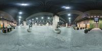 this is a 360 - view of some people walking through an empty building in the evening