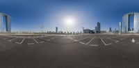 a large empty parking lot with street lights and skyscrapers in the background in the city