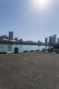 a couple of boats are parked near a dock and in front of some city skylines