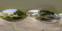 360 - view of buildings with large curved walkways and trees behind them and green vegetation