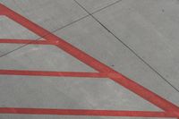 a plane on the runway at an airport in france as the red stripe is painted on the concrete