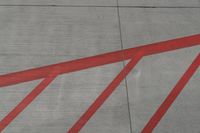 a plane on the runway at an airport in france as the red stripe is painted on the concrete