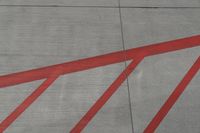 a plane on the runway at an airport in france as the red stripe is painted on the concrete