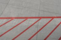 a plane on the runway at an airport in france as the red stripe is painted on the concrete