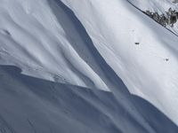 an aerial view of a person on skis jumping off a cliff into the snow