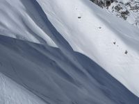 an aerial view of a person on skis jumping off a cliff into the snow