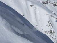 an aerial view of a person on skis jumping off a cliff into the snow